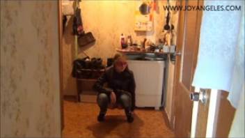 Young woman pees on the kitchen floor