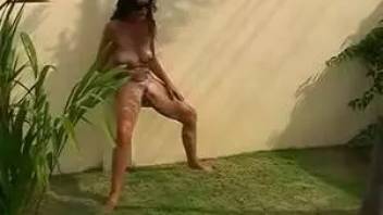 Isabella peeing in a beautiful green garden