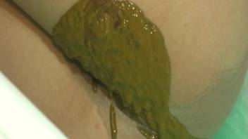 Young woman defecates in her underwear in the bathroom. Filthy buttocks
