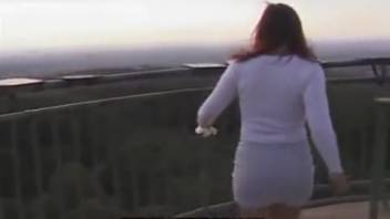 Woman defecating on the rooftop of a structure